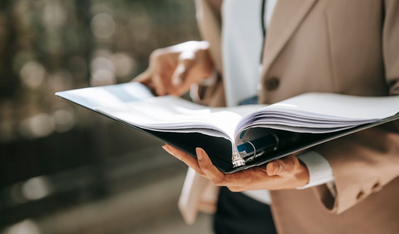 Person holding an open binder with travel documents