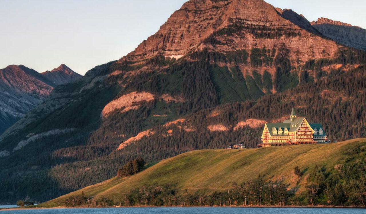 Lodge on a grassy hill with mountain and lake views