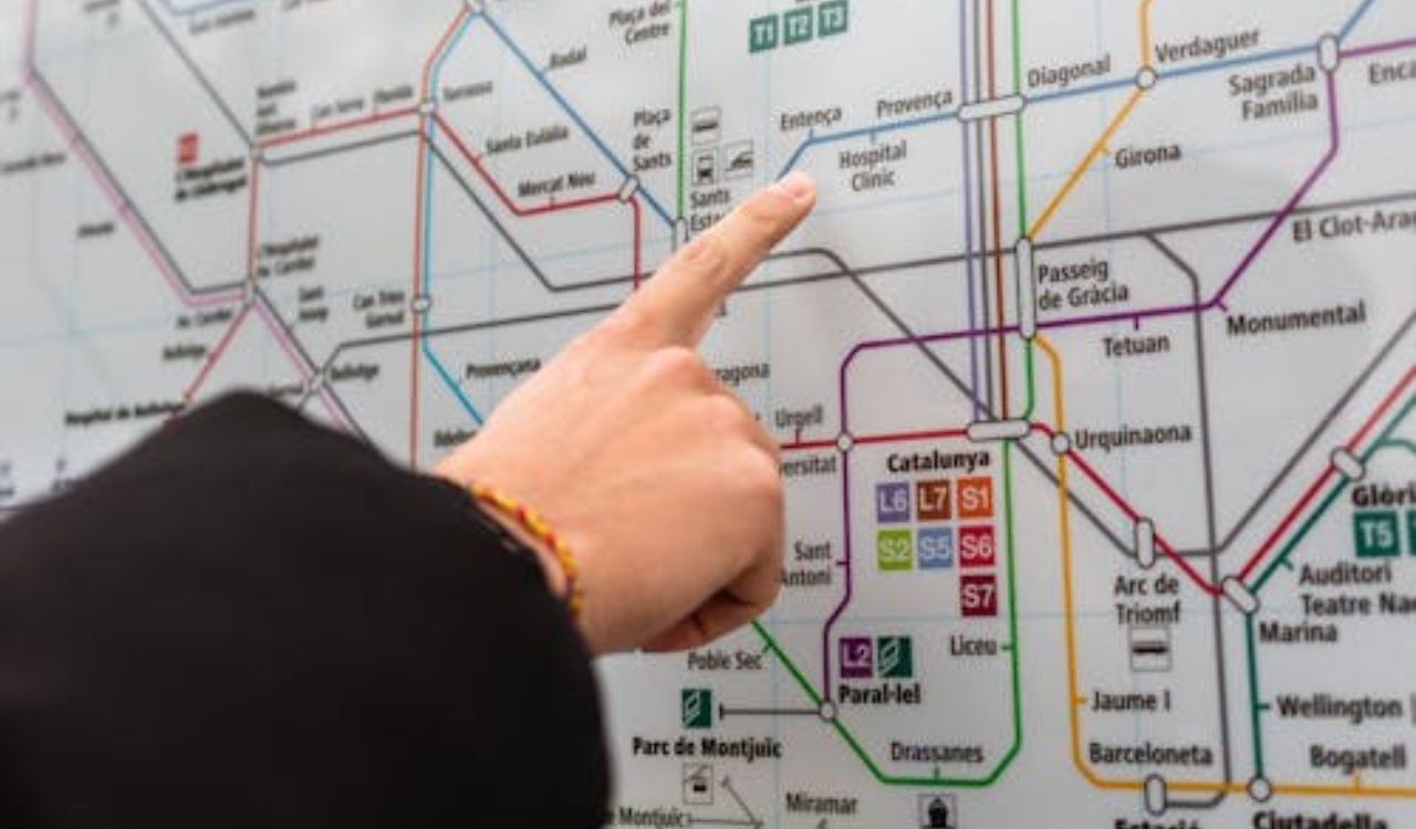 Person pointing at a metro map in Barcelona, Spain, choosing a subway route