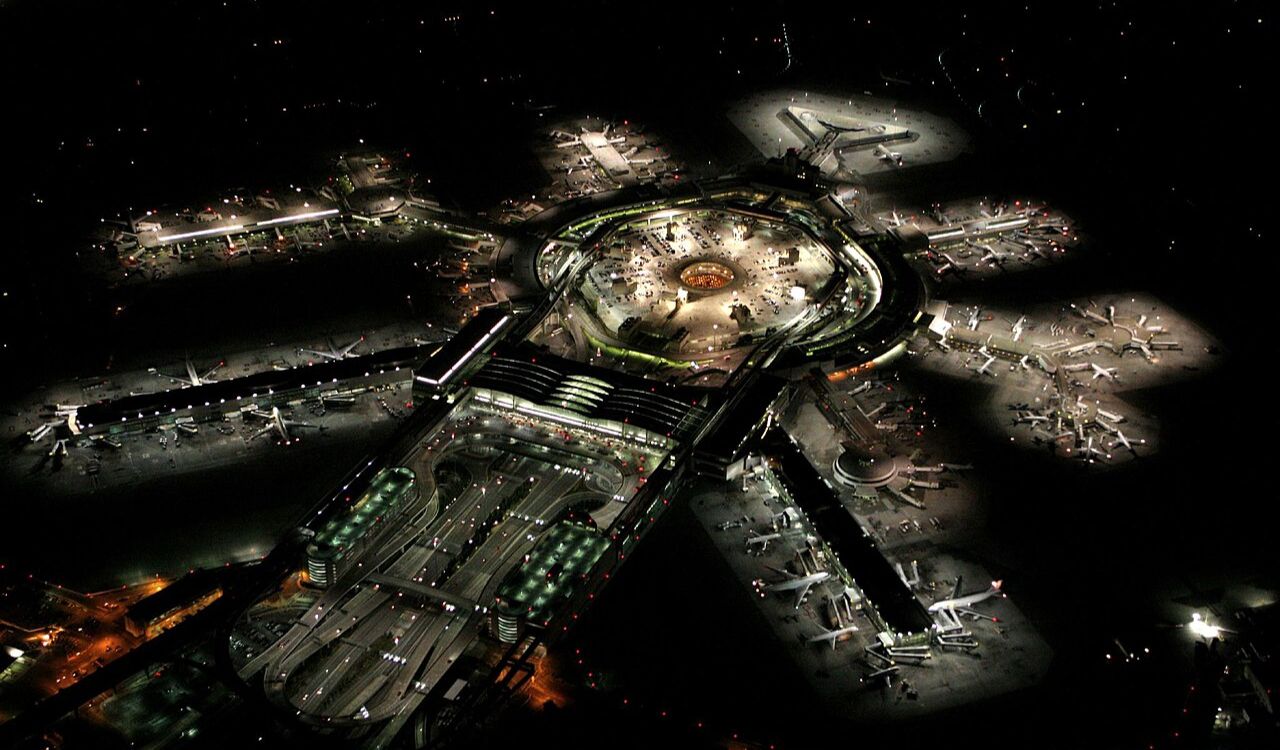 Aerial view of an airport at night showcasing multiple illuminated runways and aircraft, perfect for travel and aviation-related content