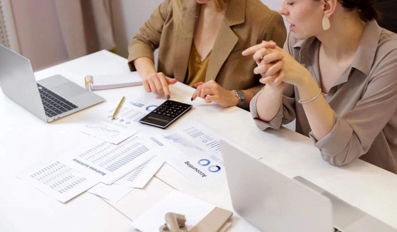 Two people are discussing documents related to travel insurance, possibly reviewing options for annual multi-trip coverage