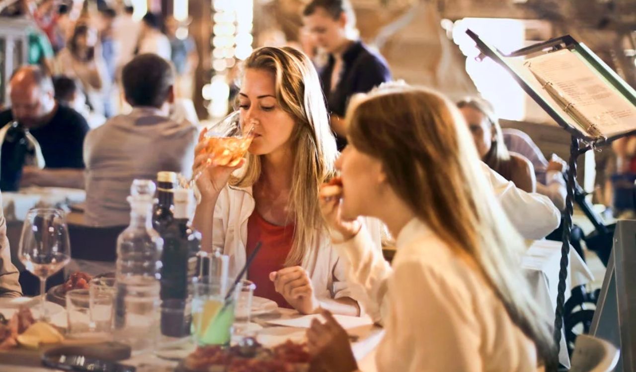 Women enjoying food and drinks at a lively local restaurant