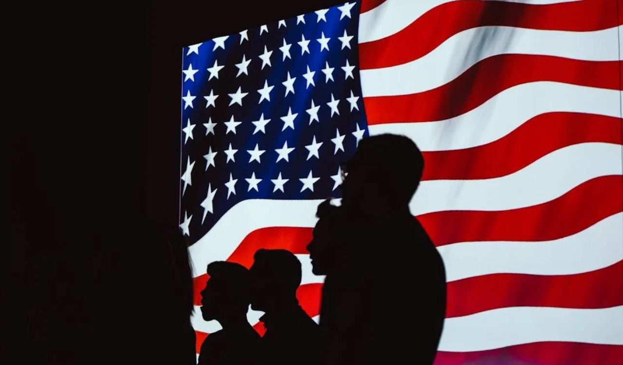 Silhouettes in front of a glowing U.S. flag, symbolizing strong American and Texan pride