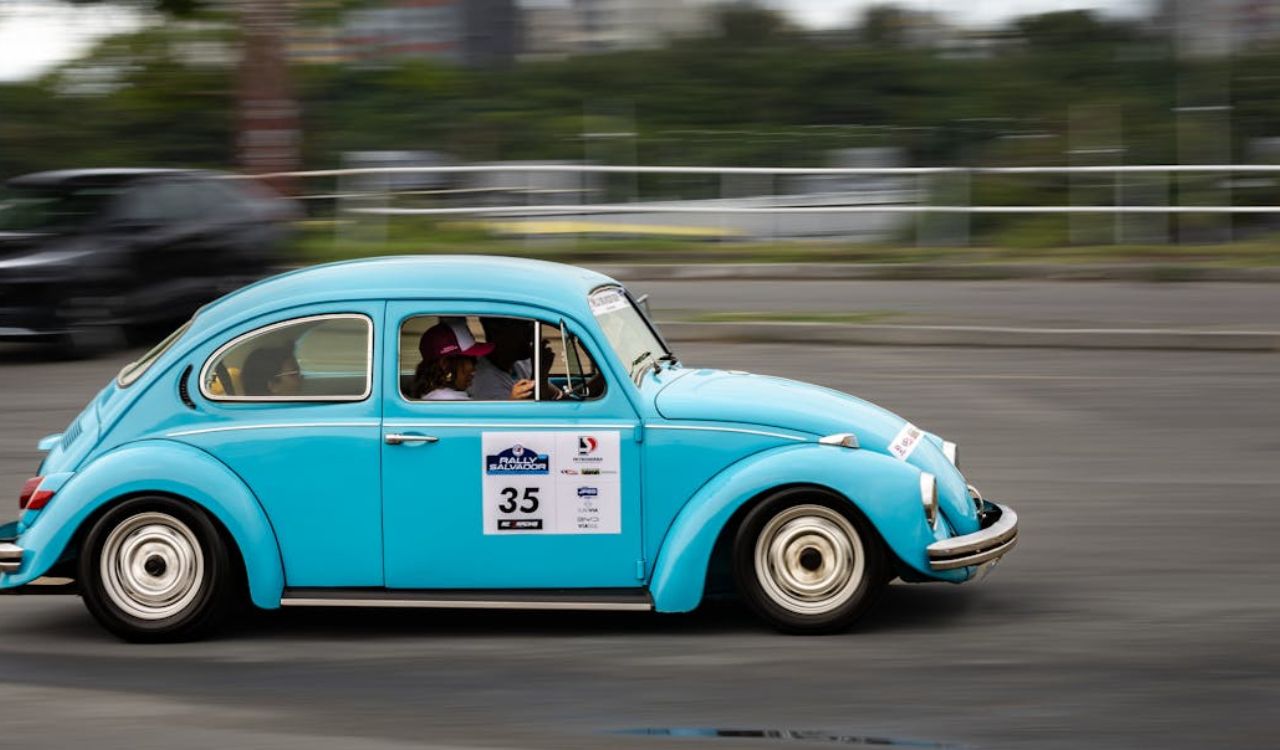 A bright blue vintage car speeds through a rally, capturing the thrill of the ride