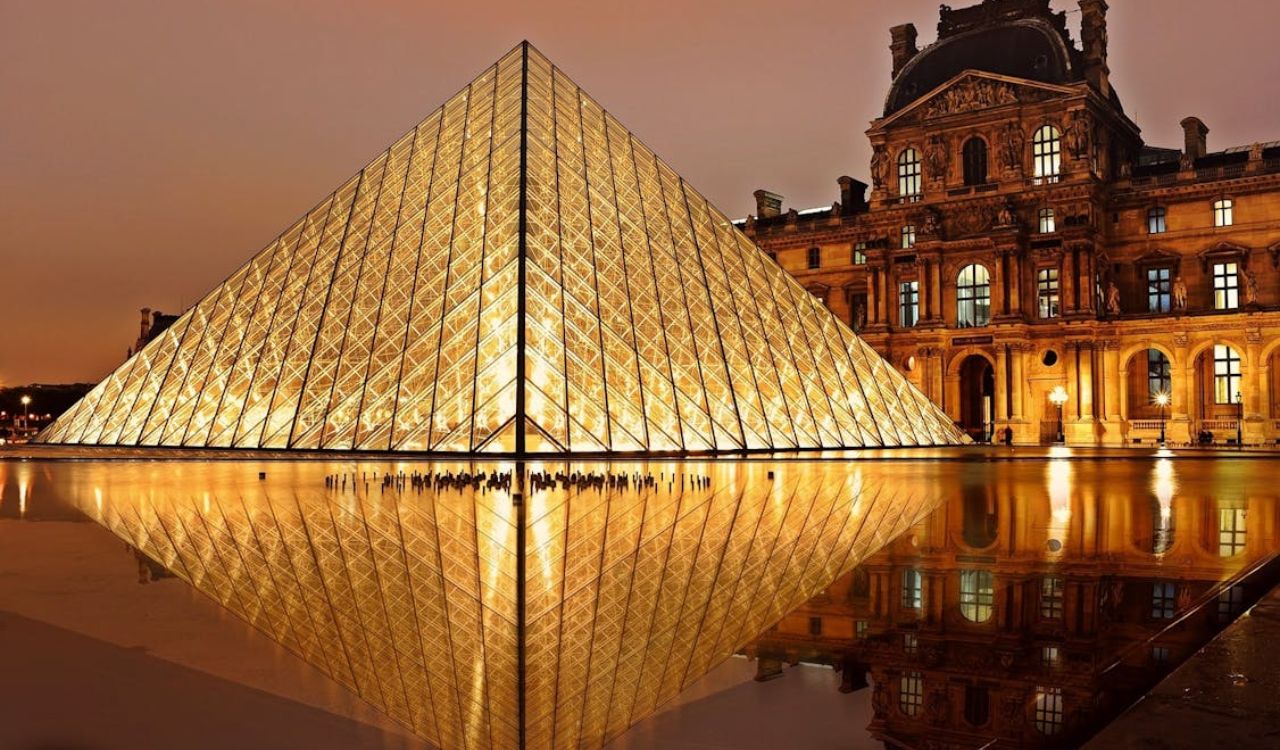 "Glowing Louvre Pyramid and historic museum building in Paris at night