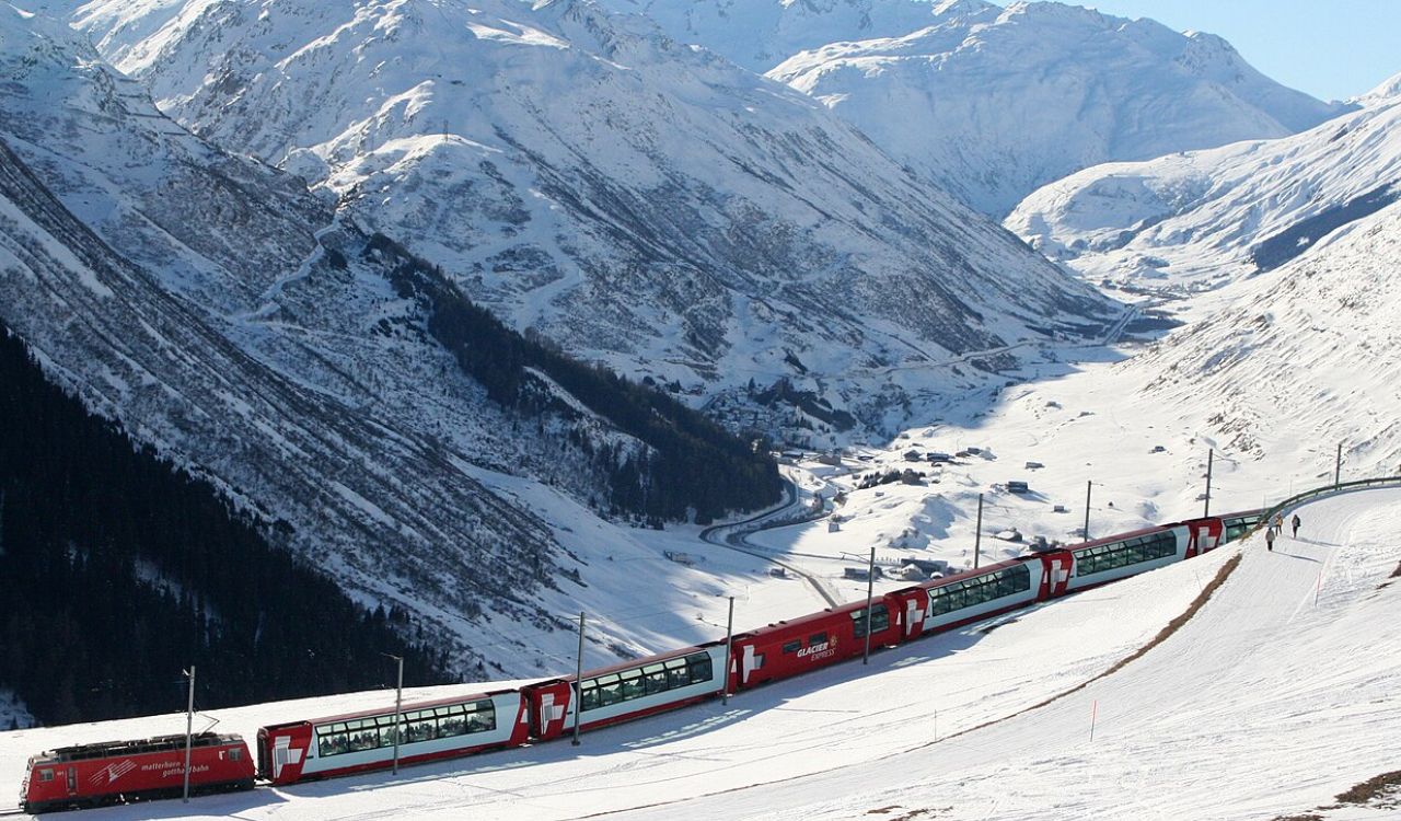 Glacier Express train winding through snowy Swiss Alps