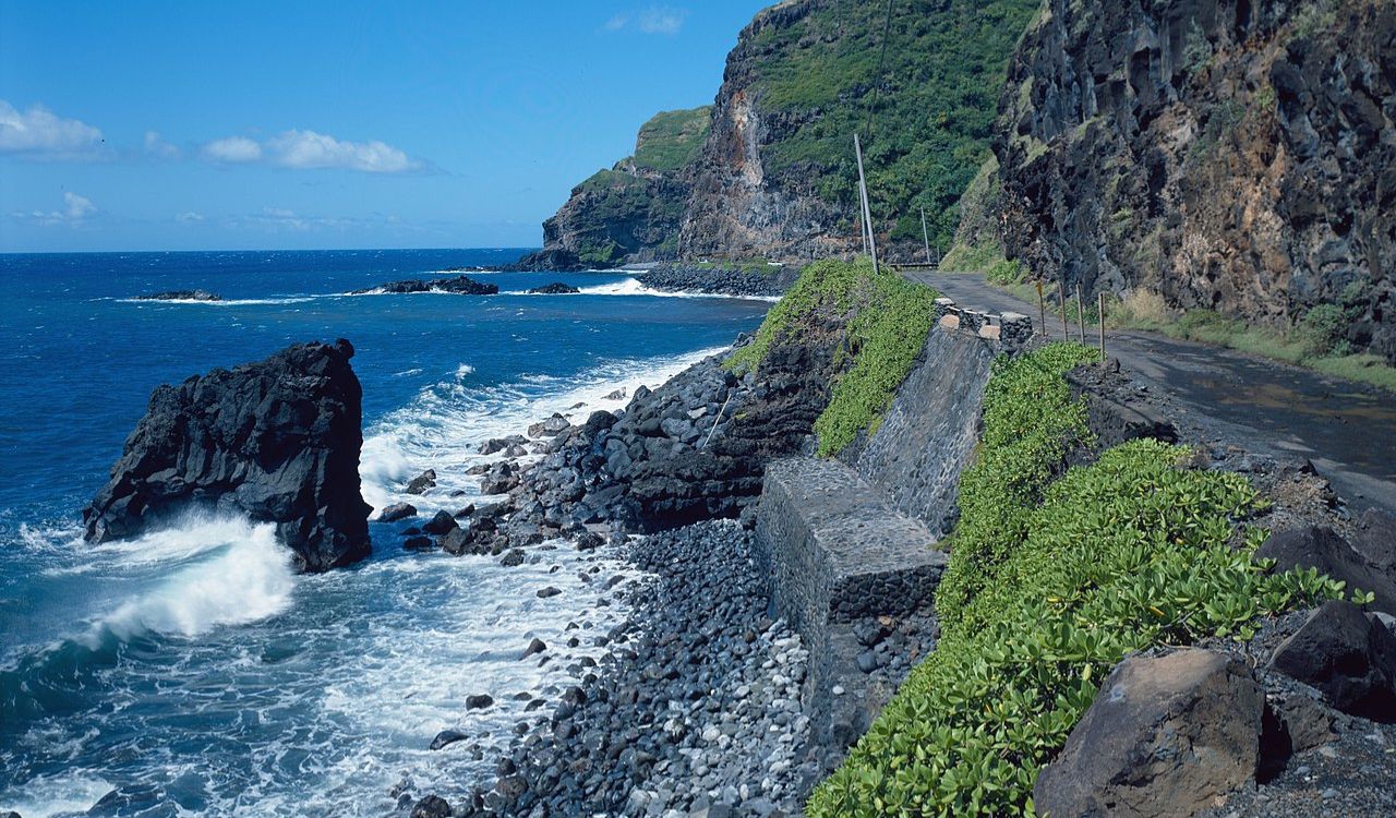 The Hana Highway in Maui winds through lush rainforests and past dramatic ocean cliffs, offering a scenic and thrilling drive
