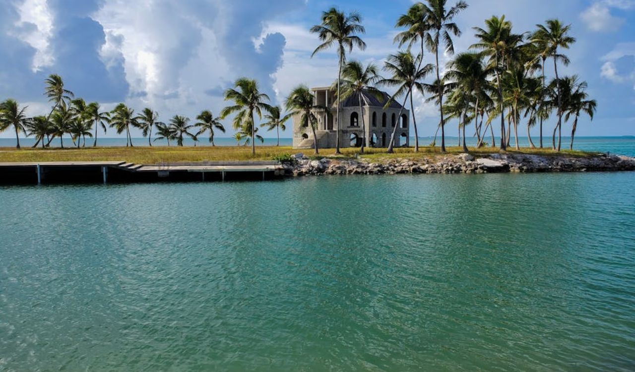 Small island with palm trees and a stone building surrounded by calm turquoise waters near Isla Bella Beach Resort in Marathon, Florida