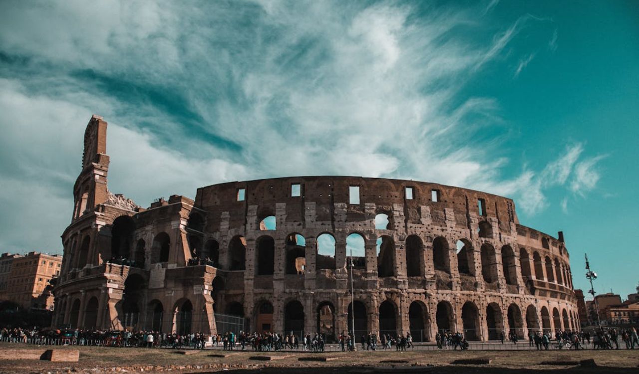 Historic Roman Colosseum in Rome, Italy under a cloudy blue sky