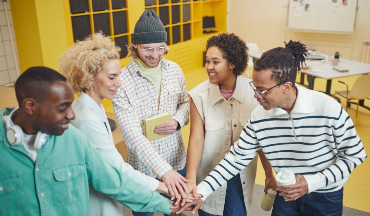 Smiling group of diverse travelers joining hands in a local greeter program