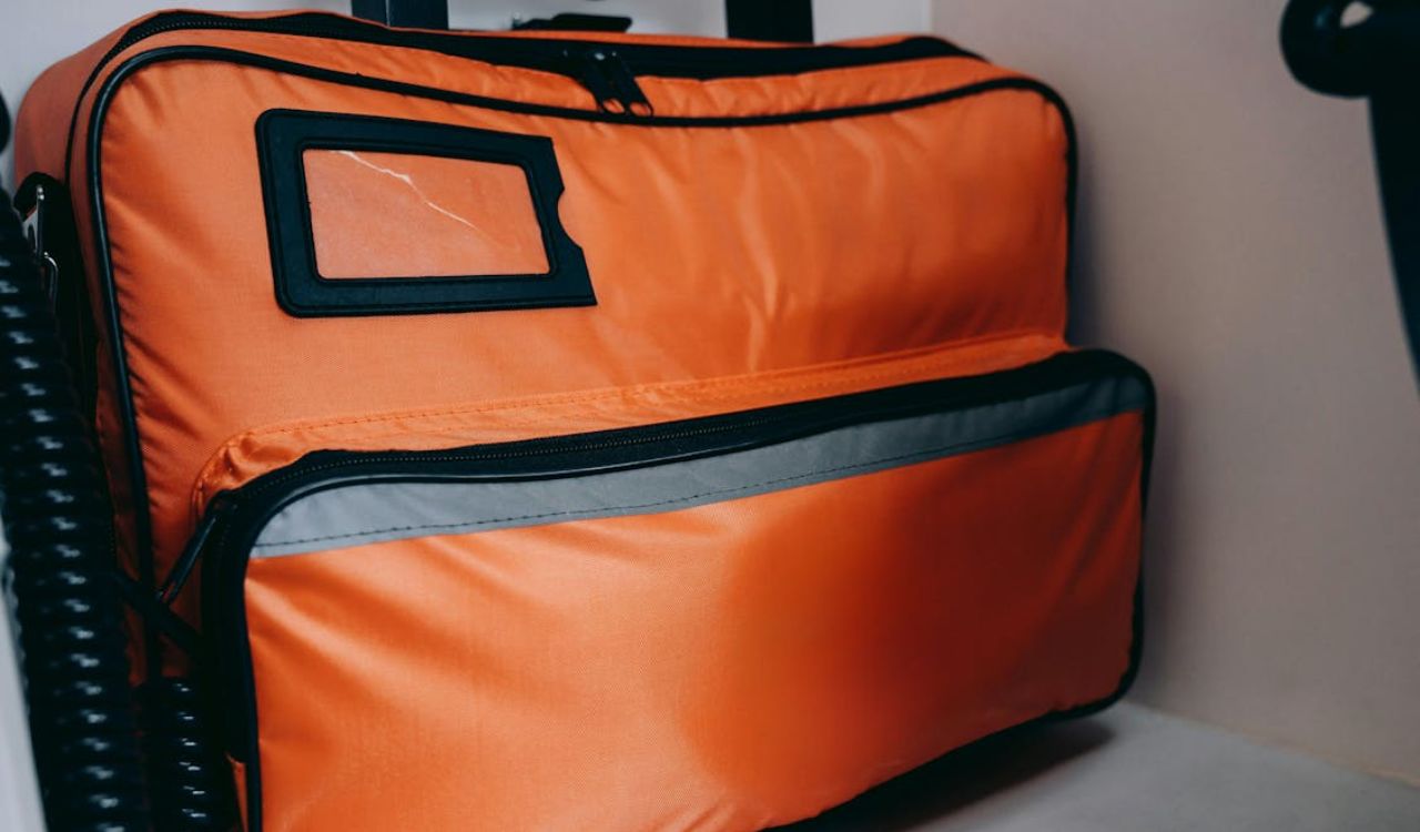 Bright orange travel bag stored in an overhead compartment