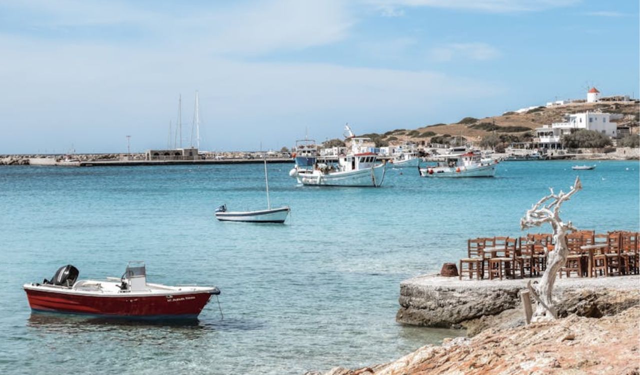 Fishing boats floating in the clear turquoise harbor of Koufonisia Island, Small Cyclades, Greece
