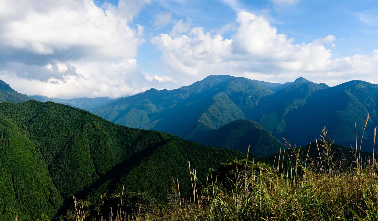 Scenic view of lush green mountains under a partly cloudy sky