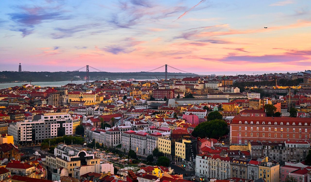 Sunset view of Lisbon, Portugal with 25 de Abril Bridge and city rooftops