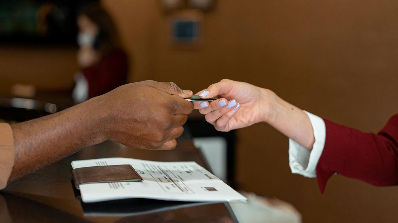 Man-Handing-a-Credit-Card-to-a-Hotel-Receptionist
