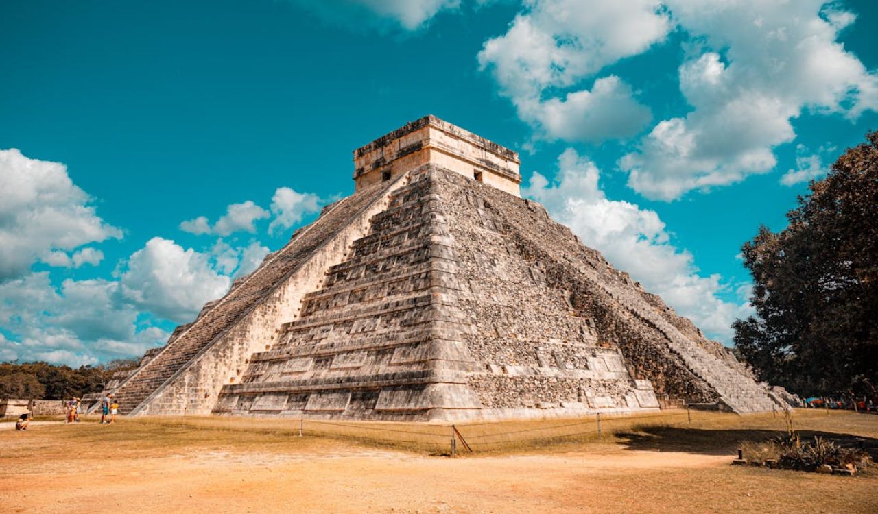 Ancient Mayan pyramid of Chichen Itza under a bright blue sky in Mexico