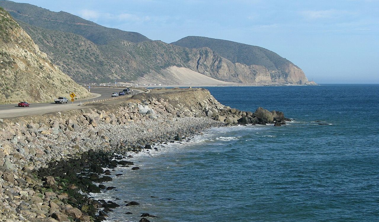 Scenic view of the Pacific Coast Highway in California, with winding roads hugging the rocky shoreline beside the ocean