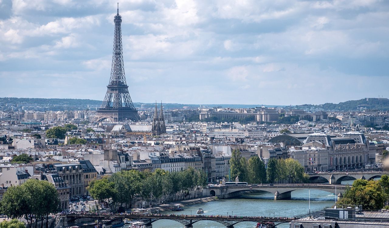 Scenic view of Paris with the Eiffel Tower and Seine River under a cloudy sky