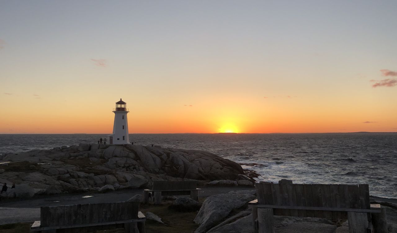 Lighthouse at Peggy’s Cove during sunset over the ocean.