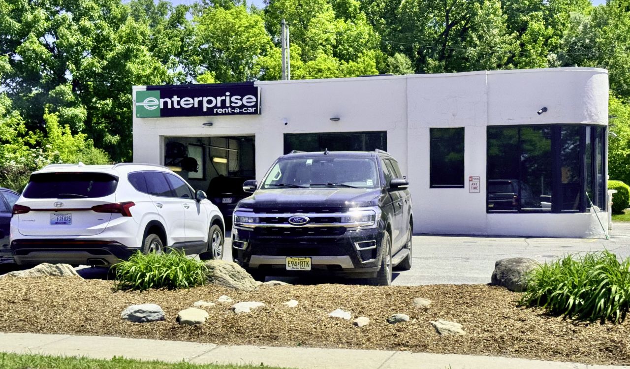 Enterprise Rent-A-Car building with parked SUVs in front.