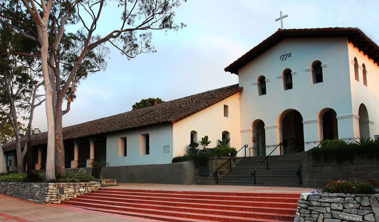 This image shows the Mission San Luis Obispo de Tolosa, a historic Spanish mission in California. Its simple architecture and serene setting make it a peaceful stop for visitors