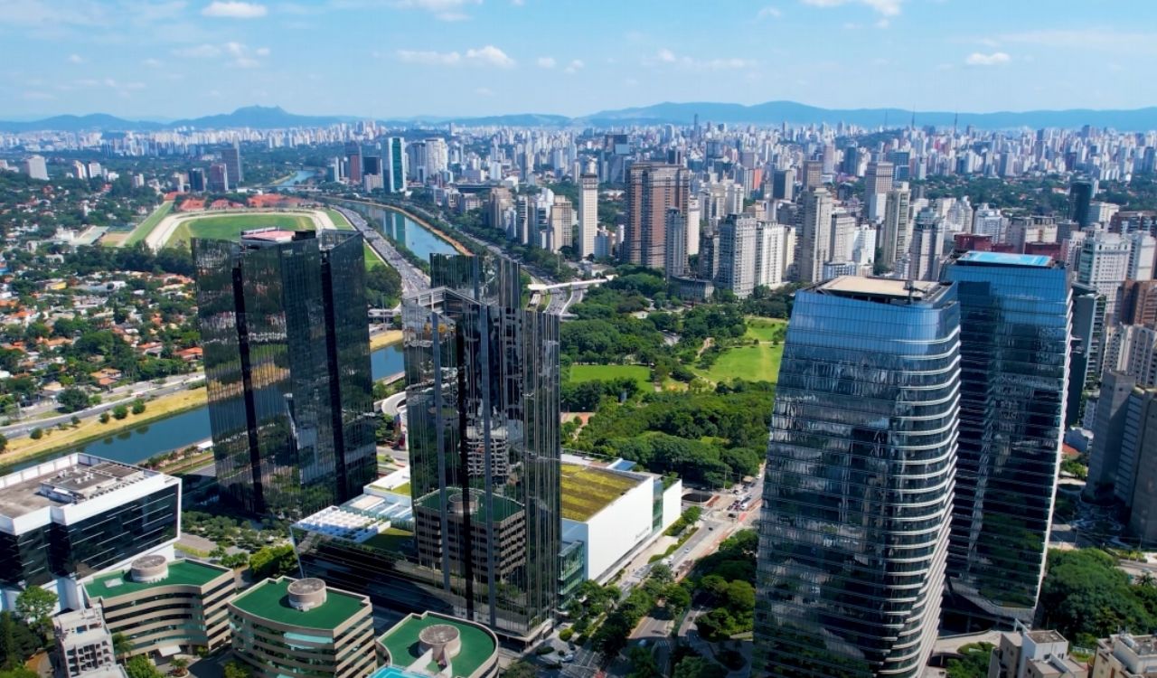 vibrant cityscape featuring modern skyscrapers, green spaces, and a river in São Paulo, Brazil