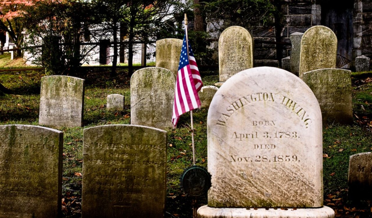 Gravestone of Washington Irving in Sleepy Hollow Cemetery with an American flag.









