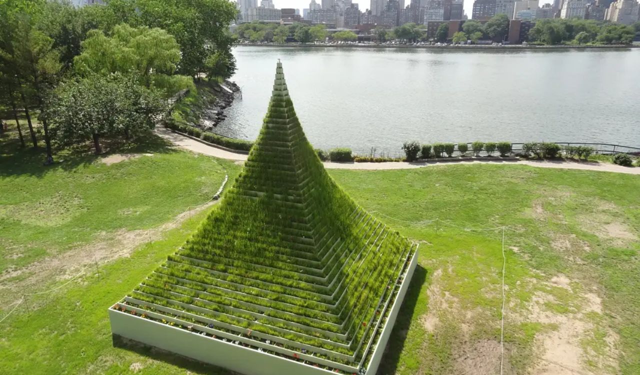 Green pyramid sculpture by riverbank