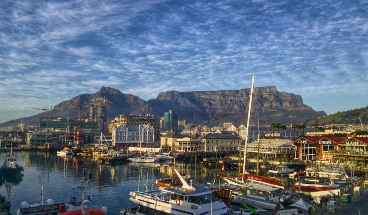 Colorful boats docked at Cape Town’s V&A Waterfront with Table Mountain in the background