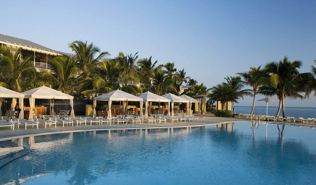 Poolside cabanas with lounge chairs and palm trees at South Seas Island Resort on Captiva Island, overlooking the ocean
