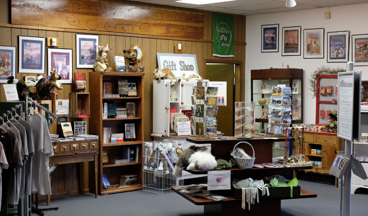 Indoor gift shop with souvenirs, books, plush toys, and postcards on display.