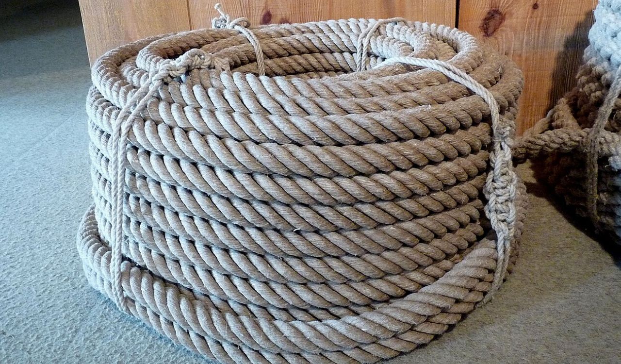 A coiled roll of thick rope, neatly tied and stacked on the floor