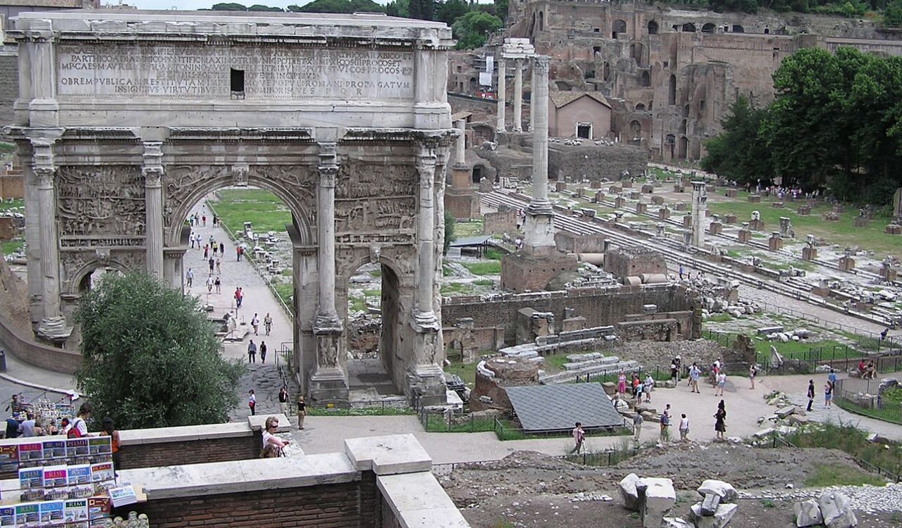 Arch of Septimius Severus in the Roman Forum with visitors exploring ancient ruins in Rome