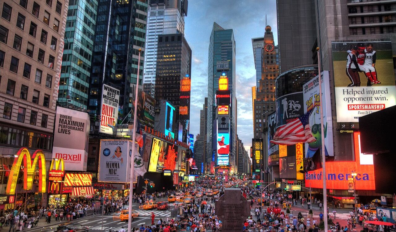 Crowded Times Square in New York City lit up with billboards and traffic