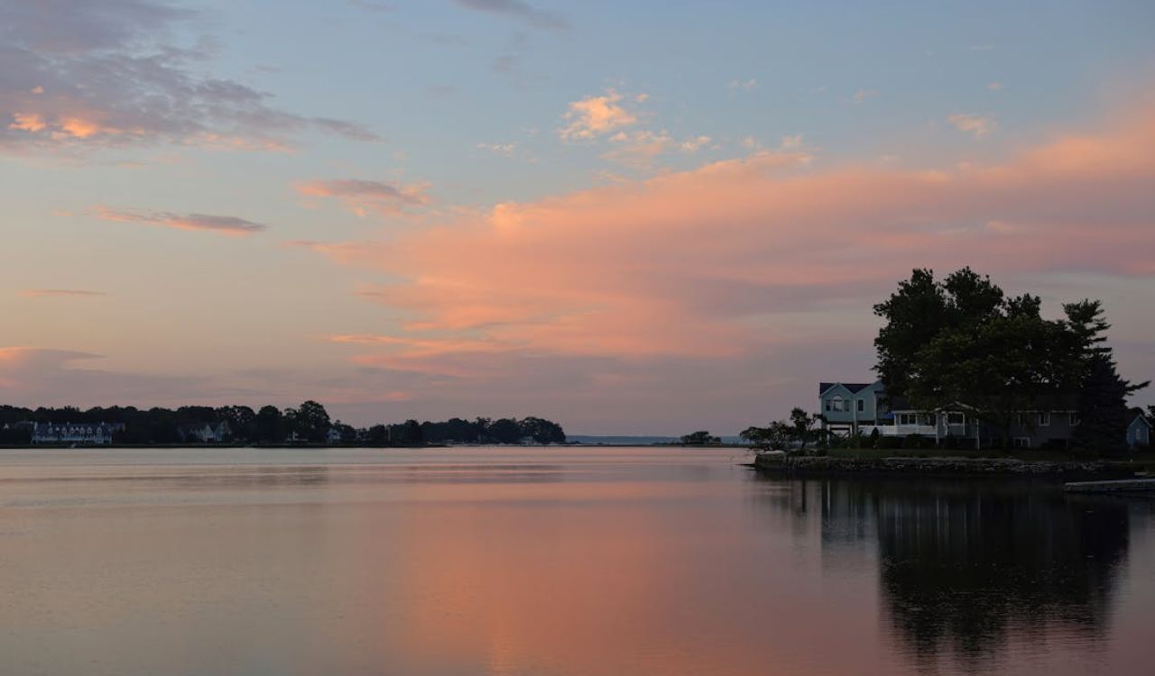 Peaceful lakefront homes at sunset with pink clouds