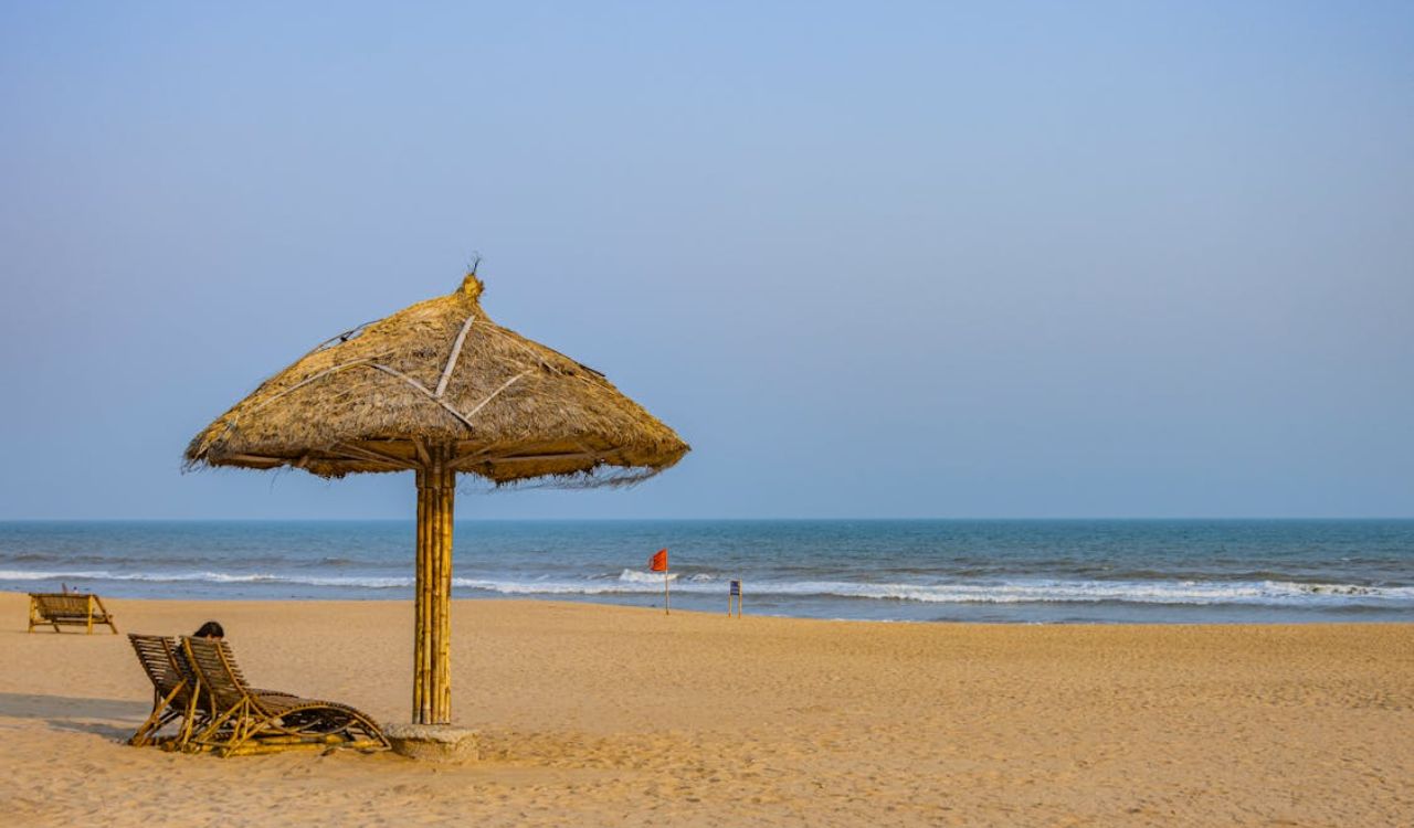 Empty beach chairs under a straw umbrella — the perks of off-season travel