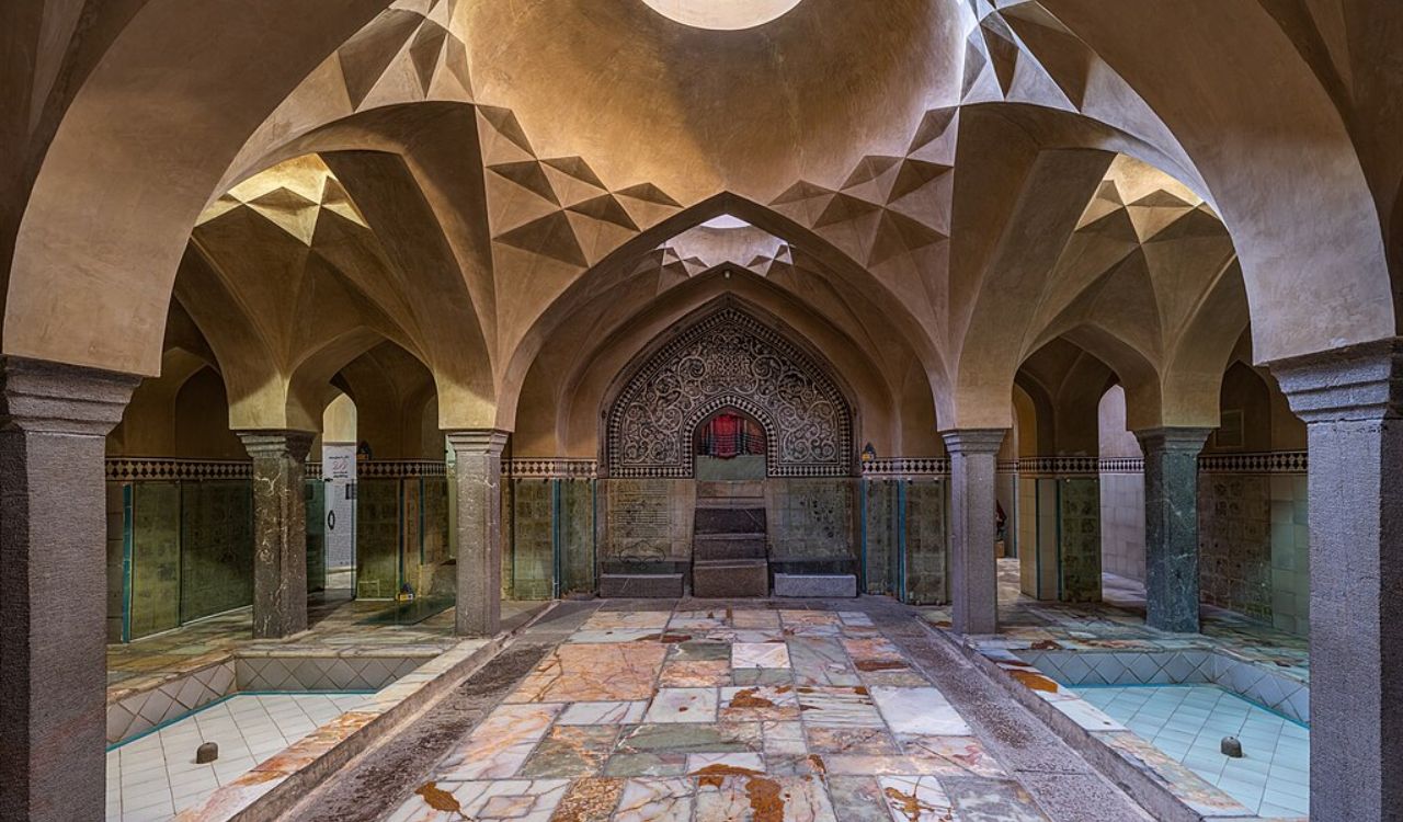 Traditional Turkish hammam with intricate arches, marble flooring, and ambient lighting reflecting historic Ottoman architecture