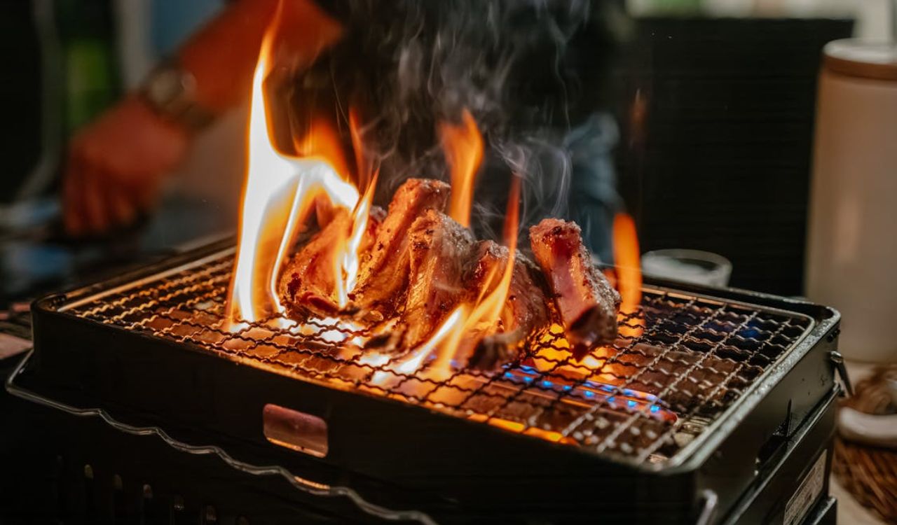 Meat grilling over open flames on a hot barbecue