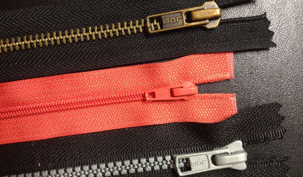 Close-up of three colorful zippers.