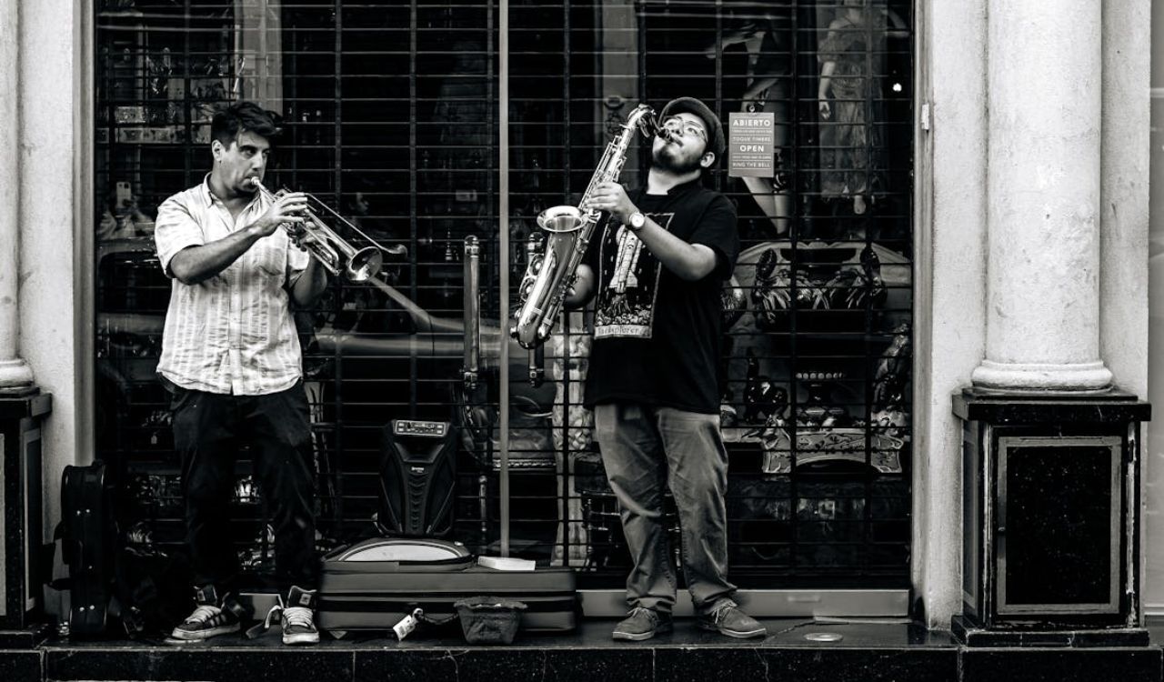 Two street musicians passionately playing trumpet and saxophone