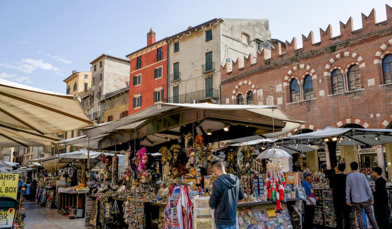 Tourists browsing colorful stalls at a local European market