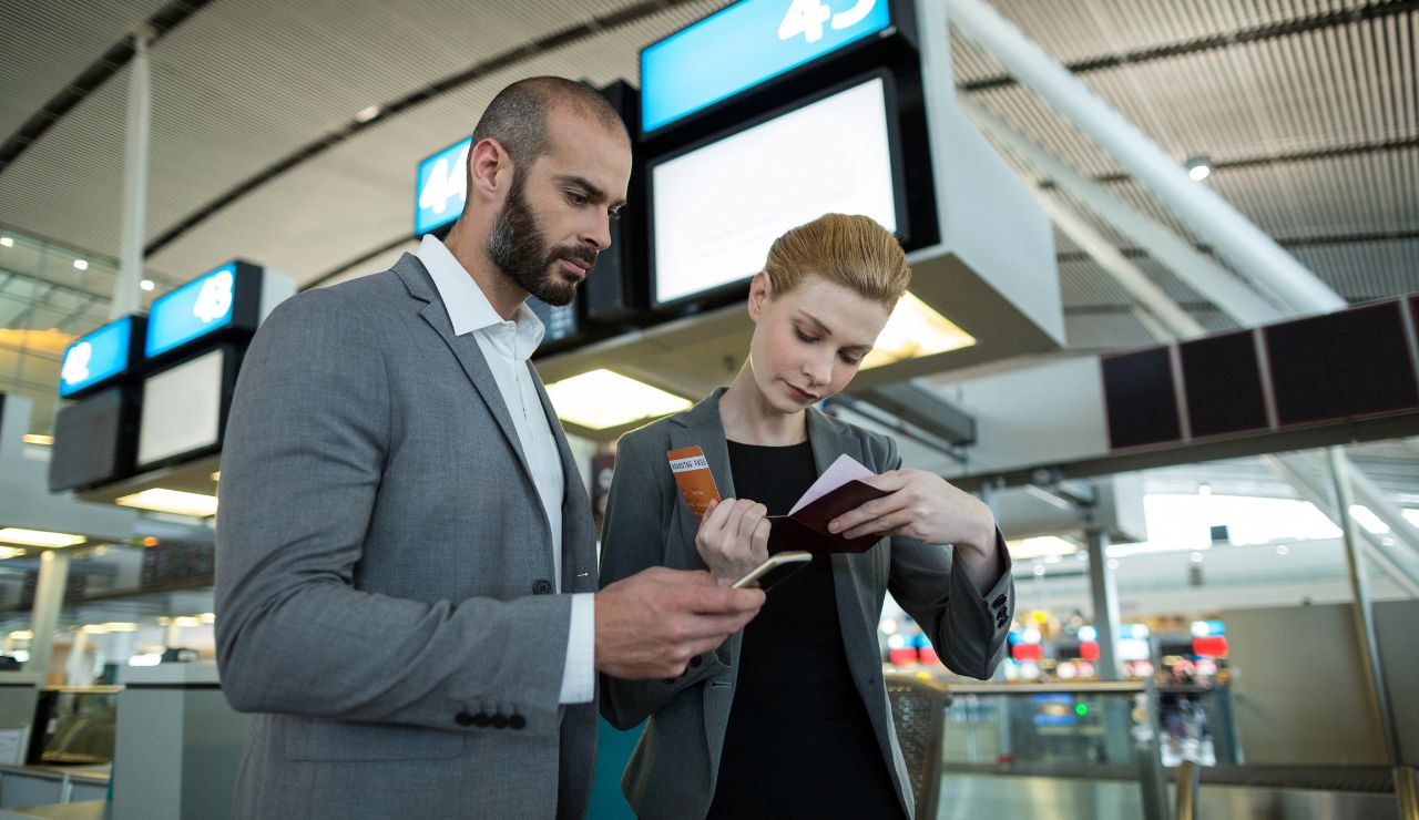 Couple checking gate info and navigating airport signs