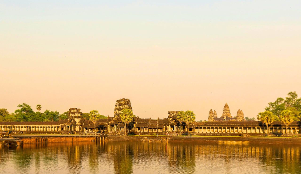 Sunrise over Angkor Wat with temple reflection in calm water