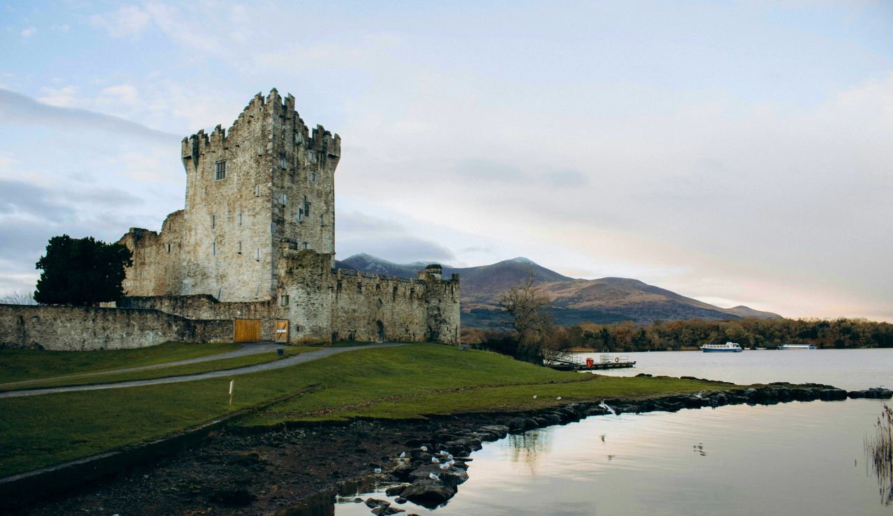 Stone castle with towers and lakefront view at Ashford Castle in Ireland