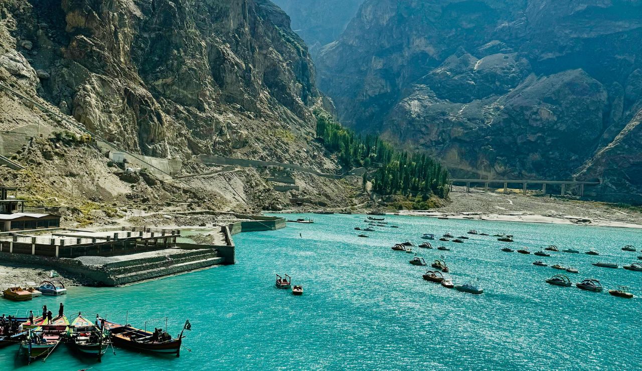 Turquoise waters of Attabad Lake with boats and mountains