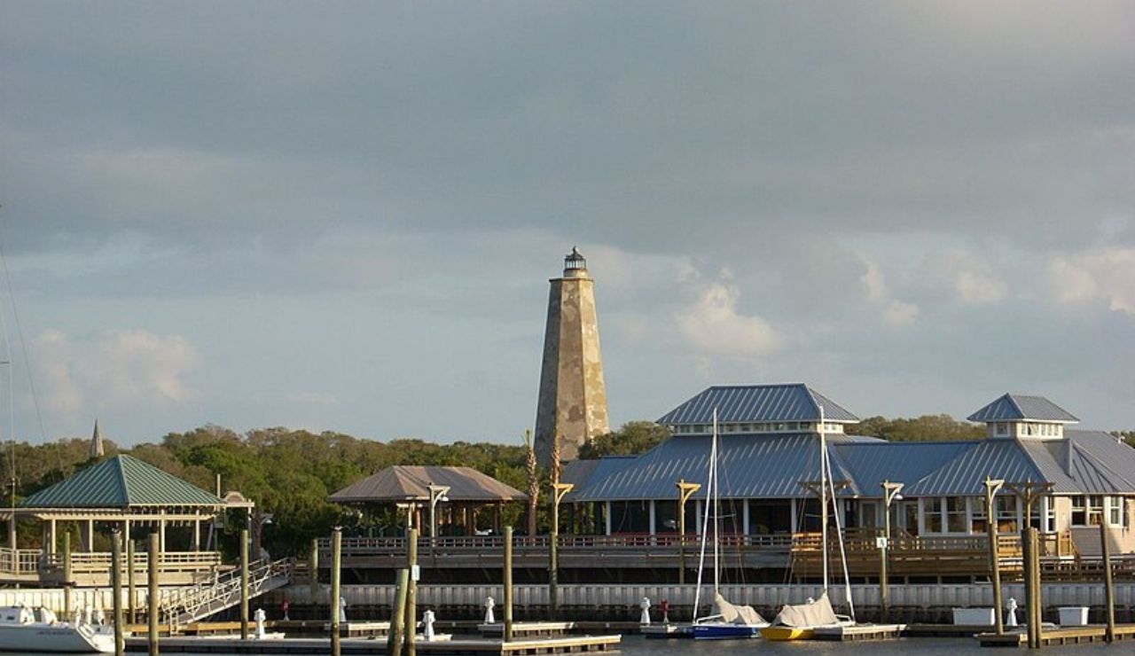 Old Baldy Lighthouse and marina buildings on Bald Head Island, North Carolina.