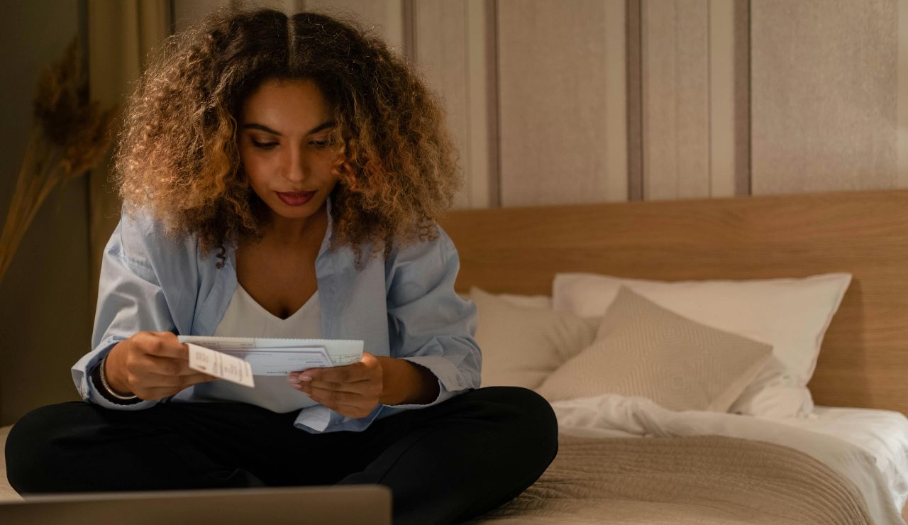 Traveler looking at insurance documents on a bed in Bali