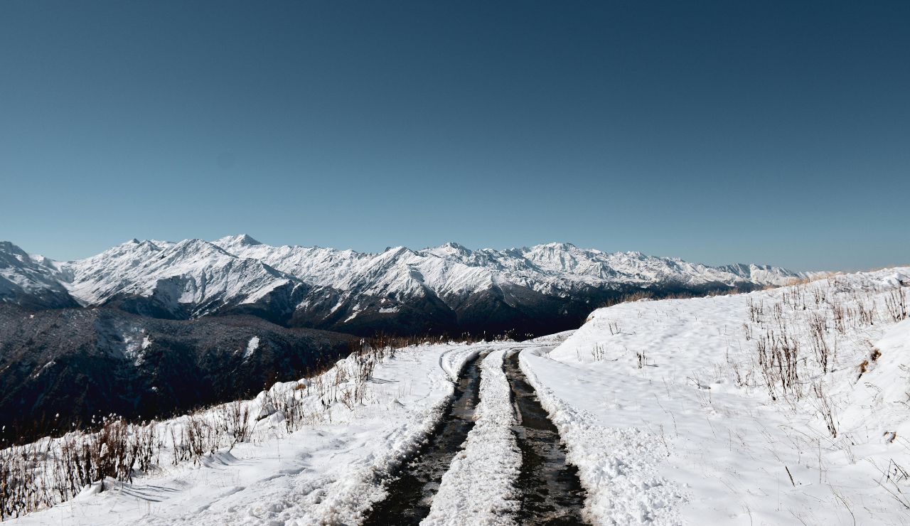 Snow-lined road with sharp switchbacks climbing into the mountains