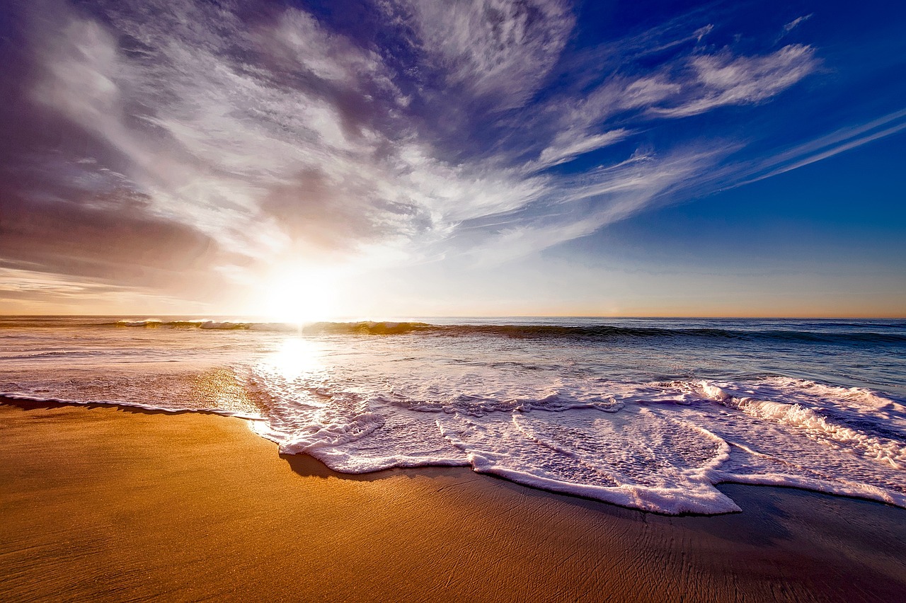 Waves wash onto a sandy beach in the morning