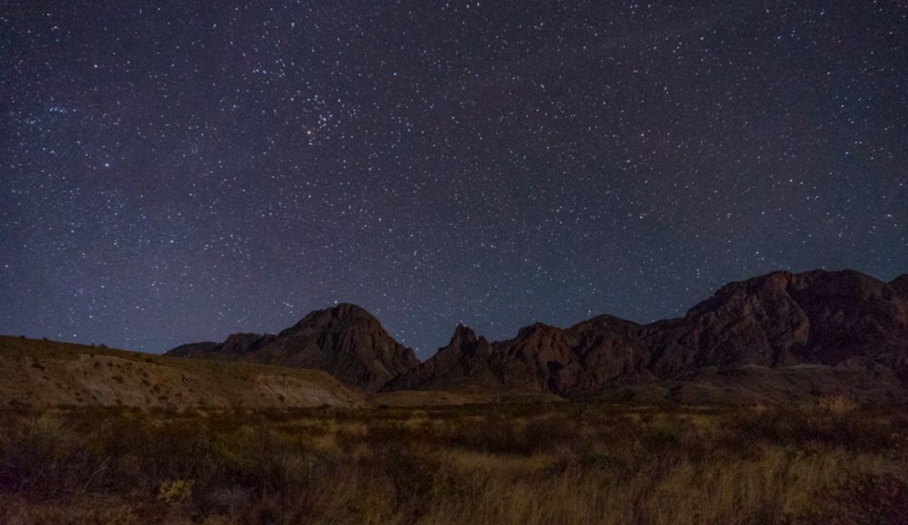 A star-filled sky glows above the rugged peaks of Big Bend, Texas.